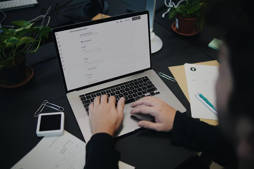 Editing an invoice in job management software on a laptop
