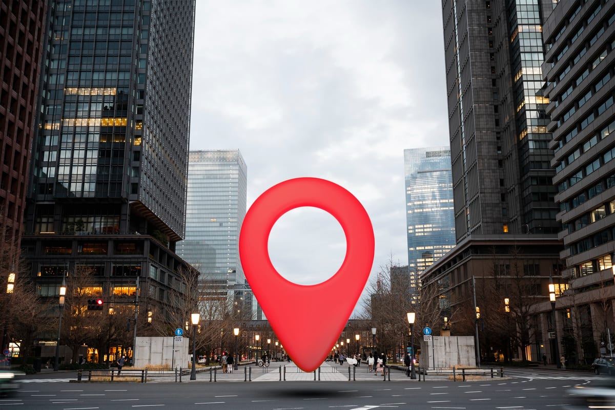 A red map pin standing over a city street, representing local search results