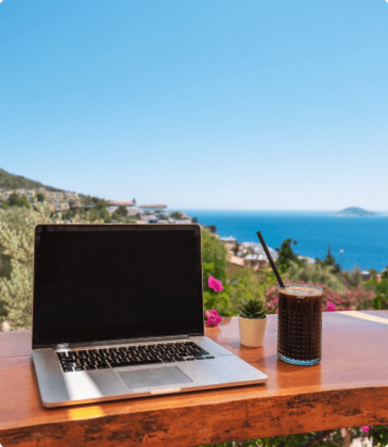 Laptop on a table overlooking the ocean